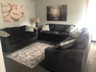 Soft gray sofas arranged in a cozy therapy lounge space.
