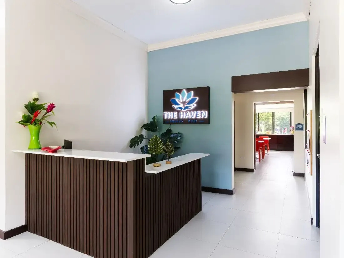 Front desk with logo sign and hallway leading to dining area.