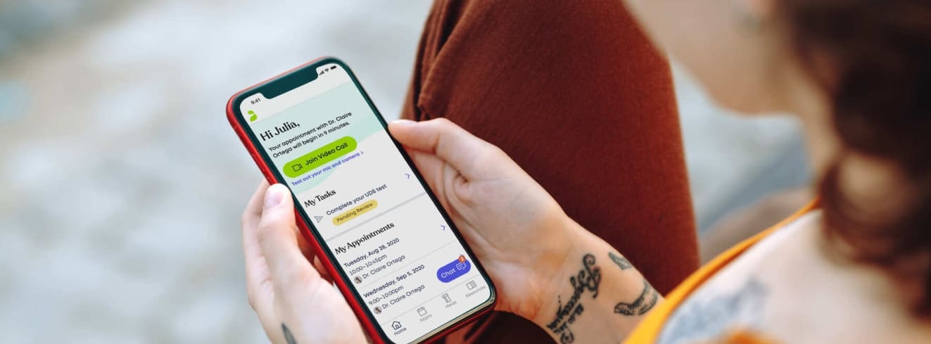 Person holding smartphone with telehealth app open