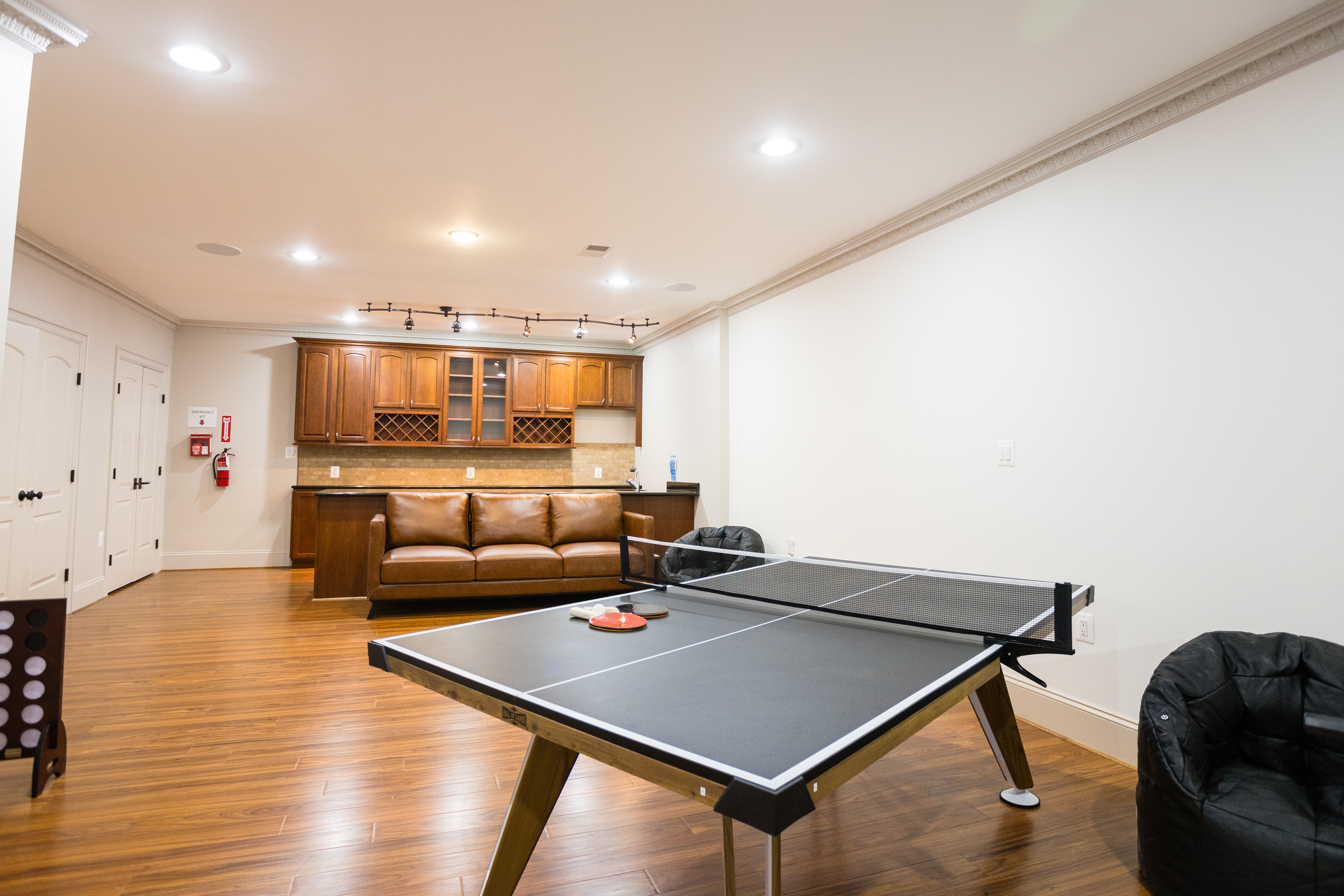 Ping pong table in rec room with couch and bar area