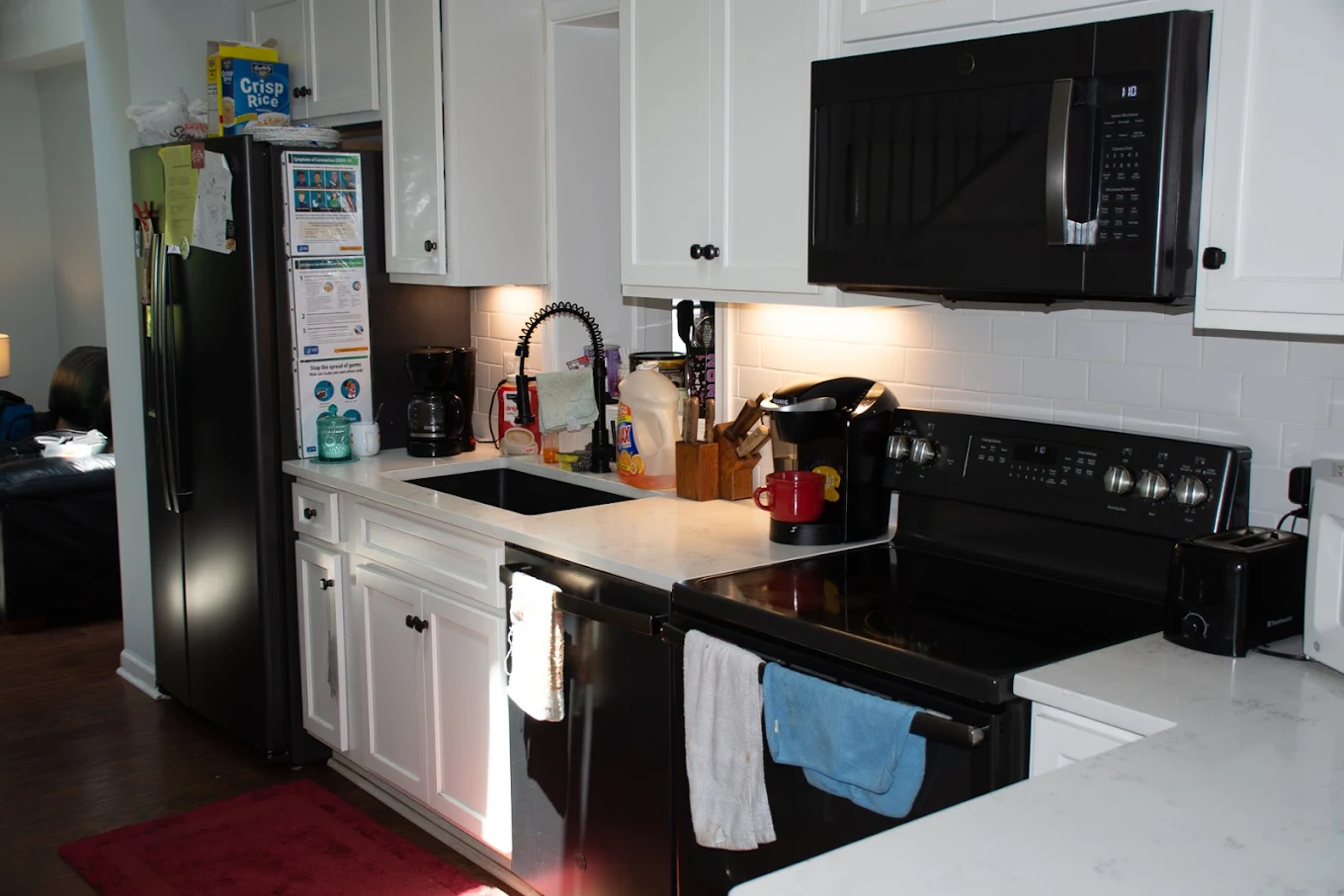 Modern rehab kitchen with black appliances and white cabinets