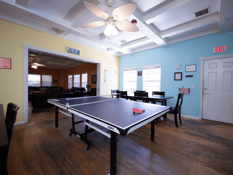 Ping pong table with casual seating and fan-lit ceiling