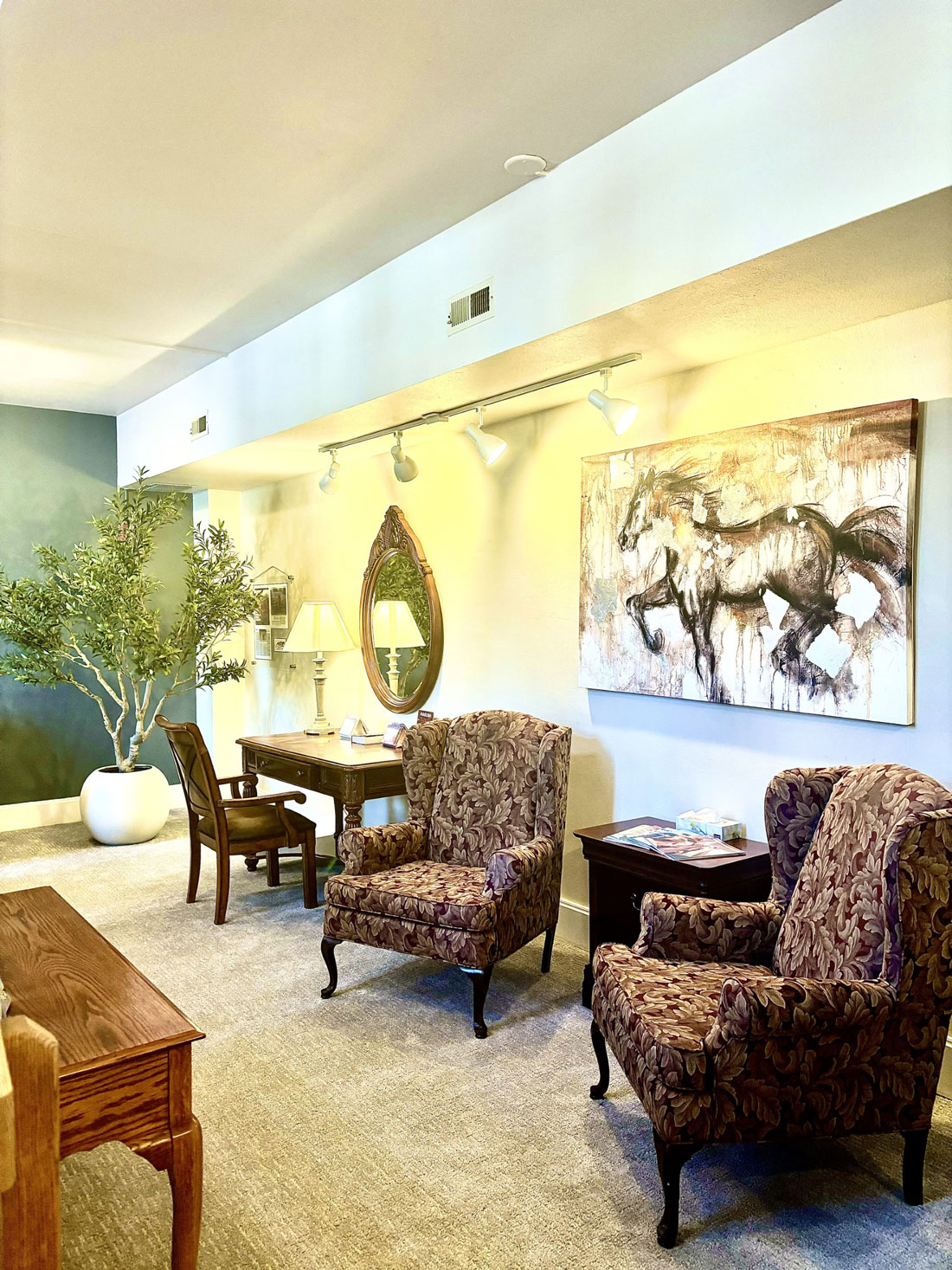Lobby with armchairs, artwork, and desk