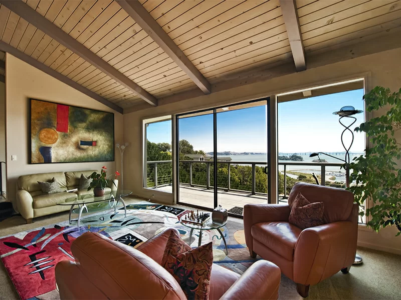 Lounge area with large windows overlooking water and surrounding landscape