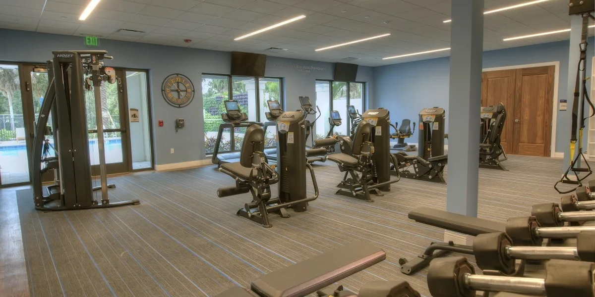 Gym with machines and pool view through glass doors