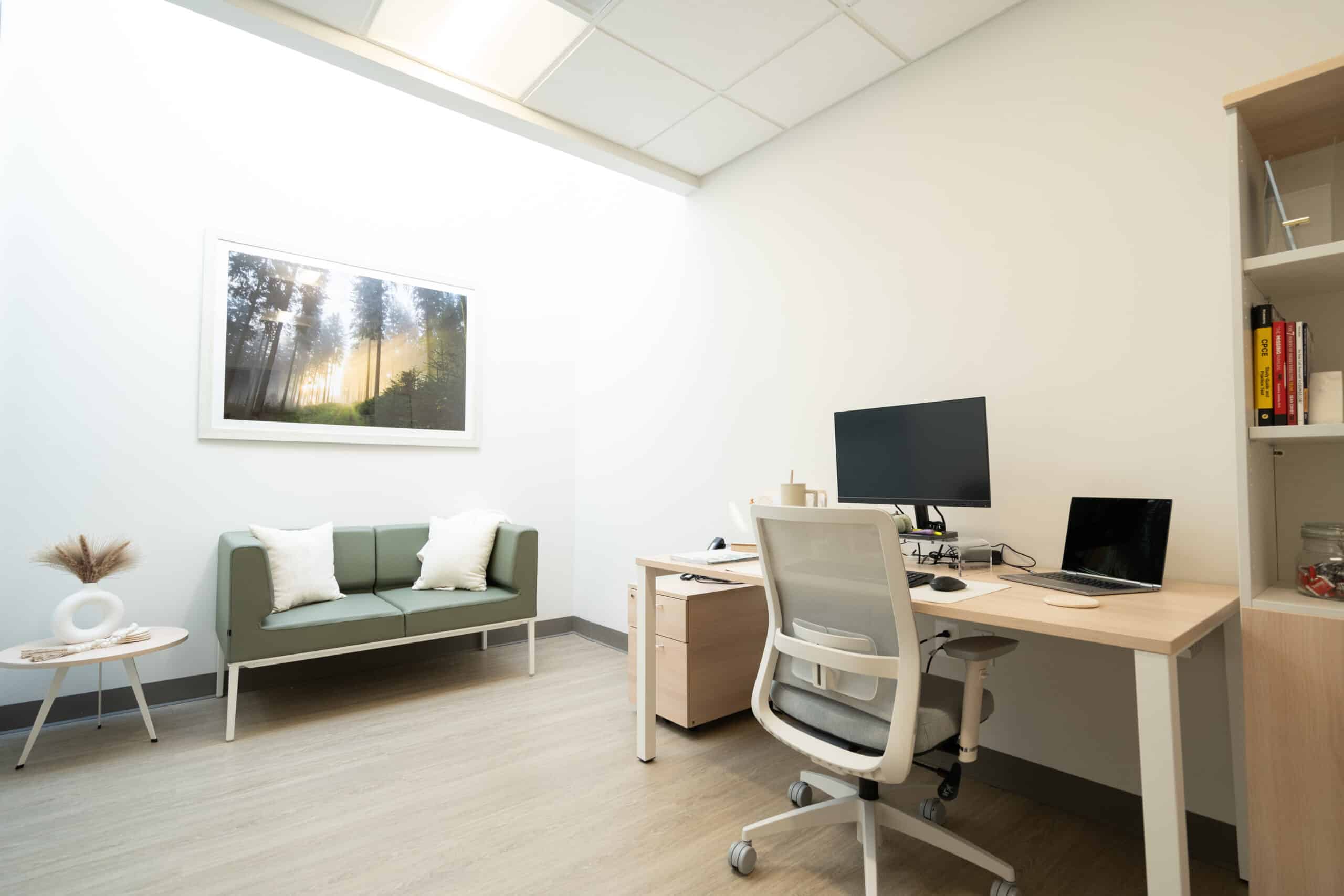 Private office with desk, chair, and green couch