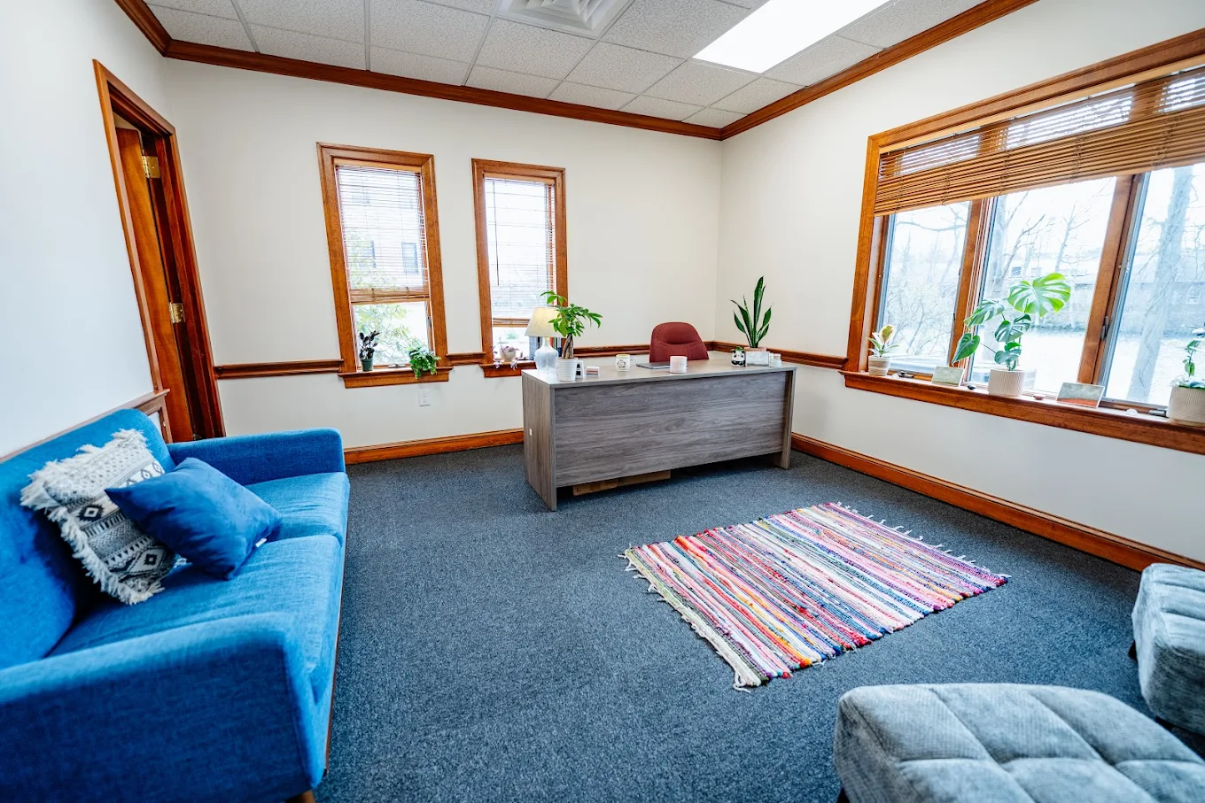 Private office with desk, sofa, and large windows