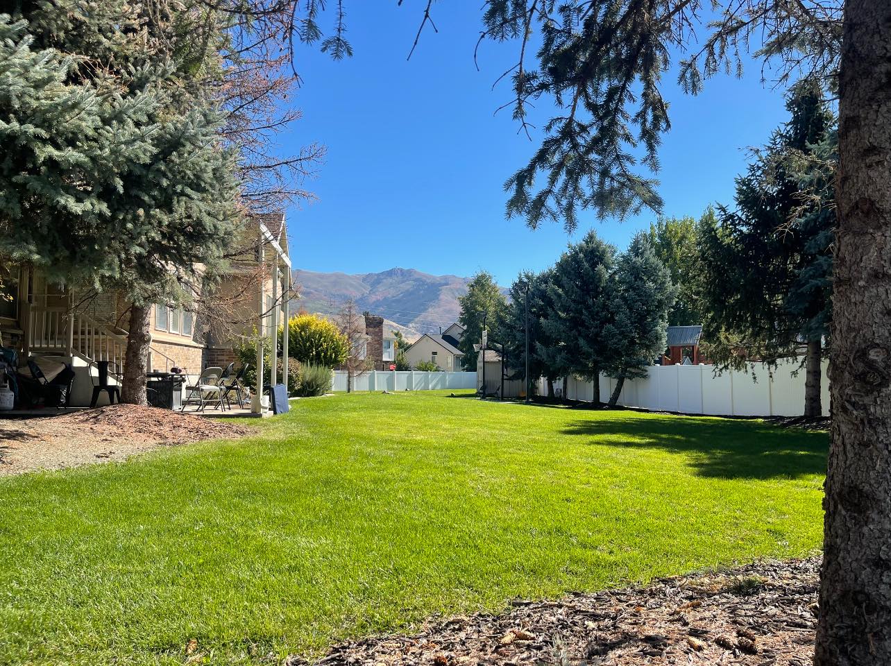 Lawn with mountain views and a white fence