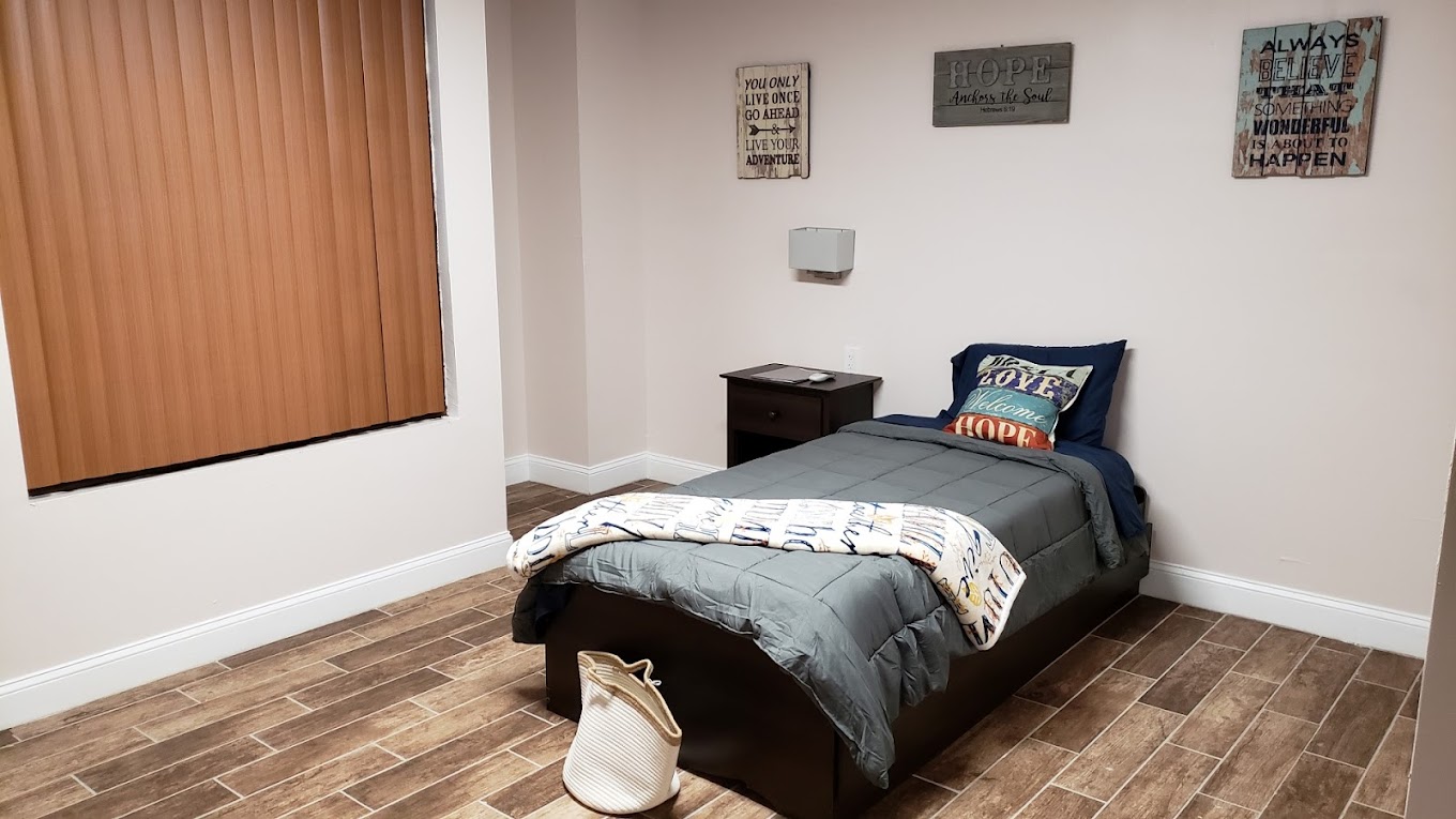 Cozy single bedroom with motivational wall art.