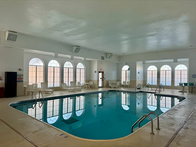 Indoor pool with lounge chairs and arched windows