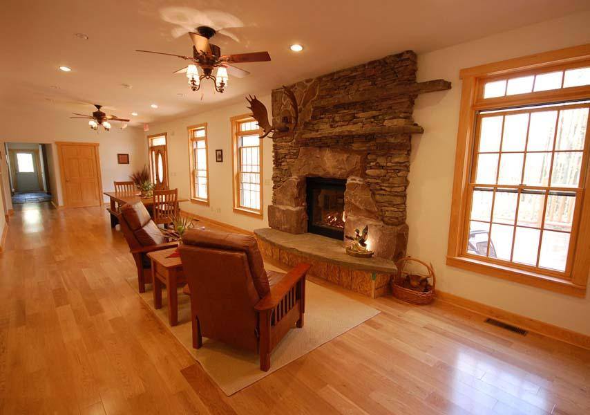  cozy living room with a stone fireplace and wooden furniture