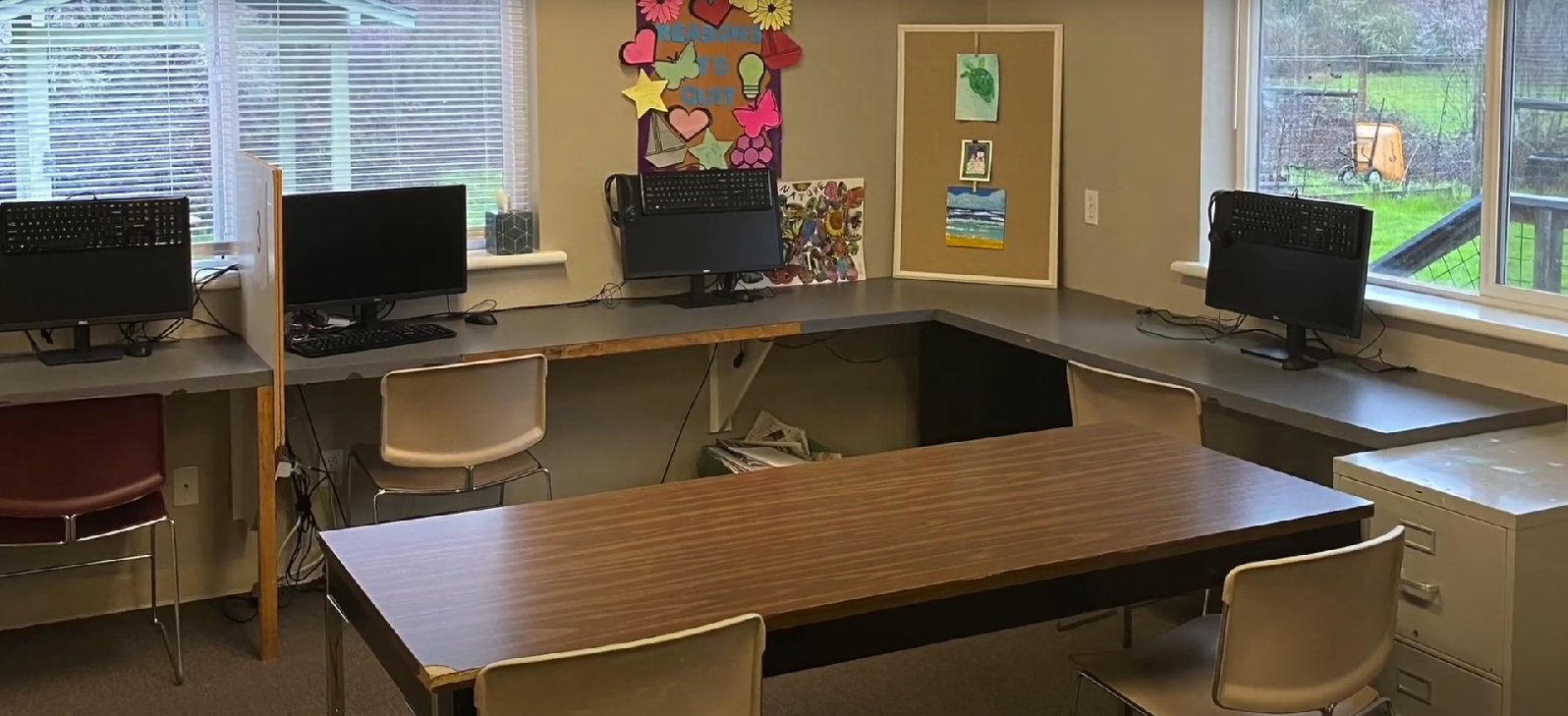 Computer lab with desks, computers, and chairs in a bright room