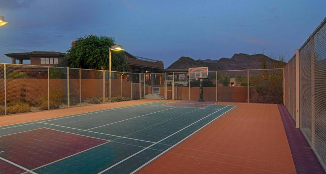 Outdoor basketball court with hoop and mountain backdrop