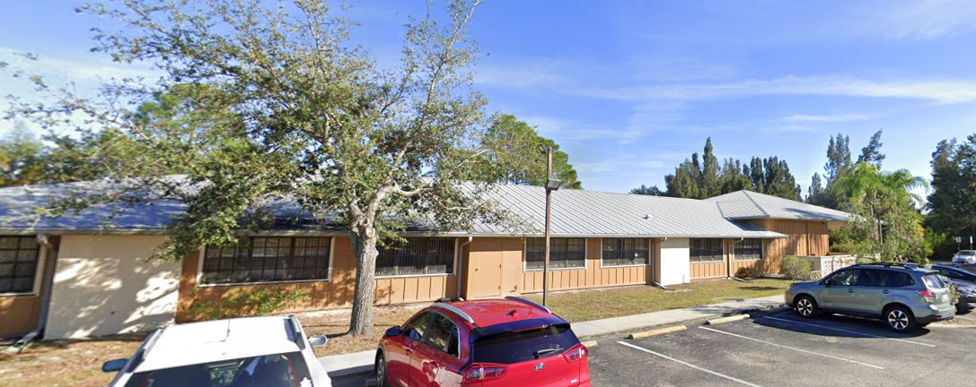 Long exterior view with windows and parking spaces