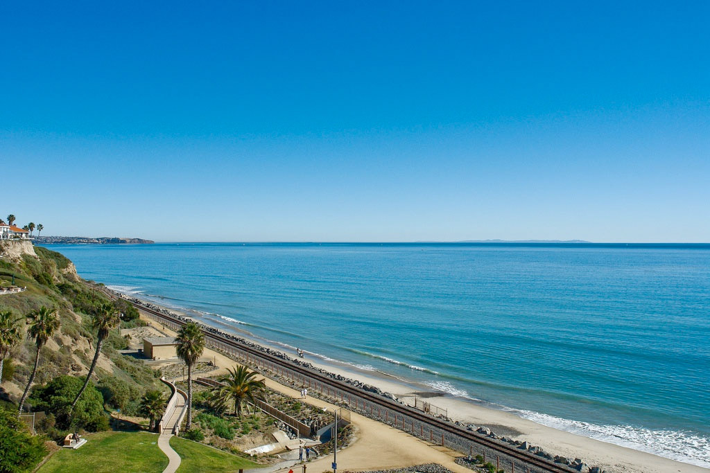 View of coastal path lined with palm trees.