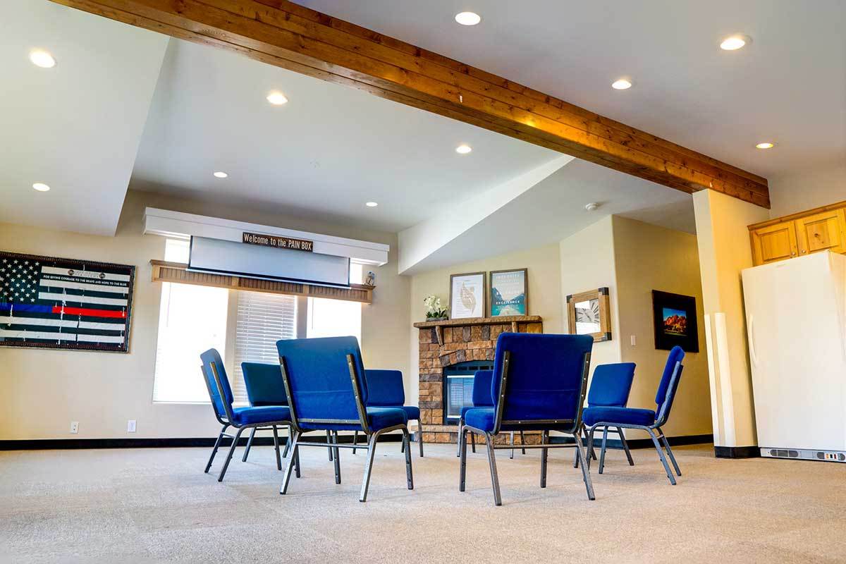 Group therapy room with circle chairs and stone fireplace
