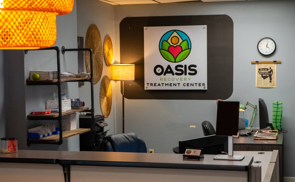 Reception desk area with Oasis Recovery Center signage and office workspace