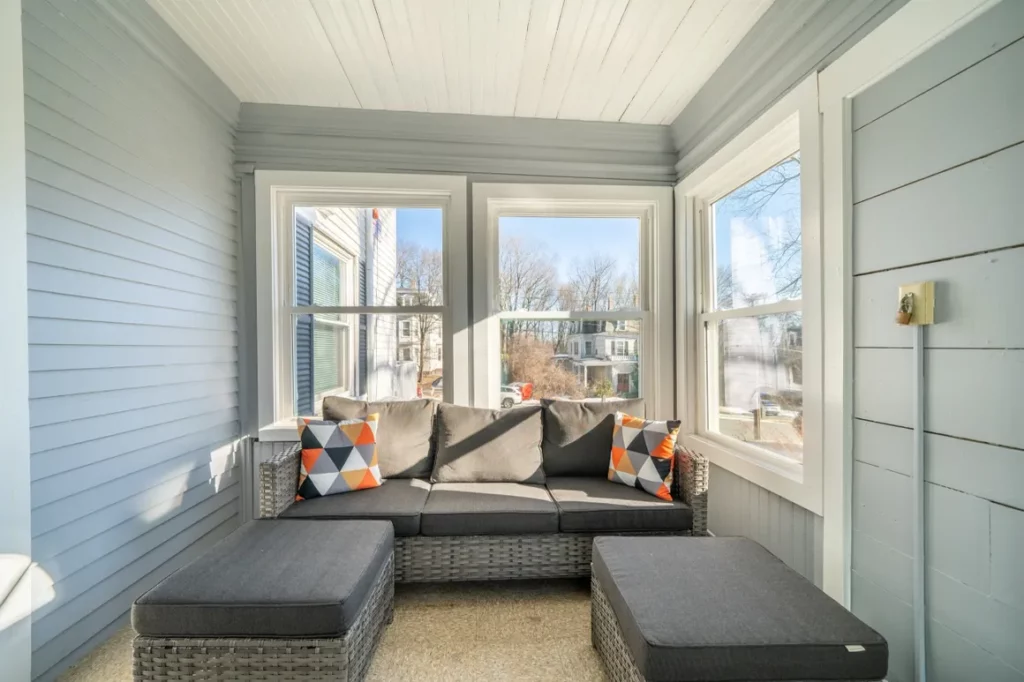 Enclosed sunroom with seating and large windows