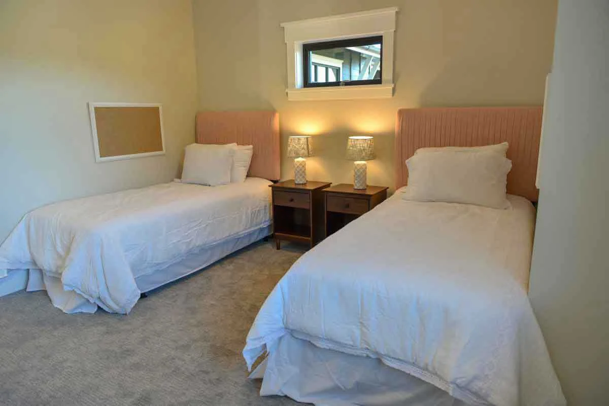 Twin beds with pink headboards and shared nightstand