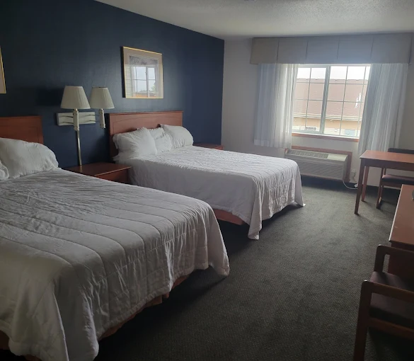 Bedroom with two beds, desk, and window