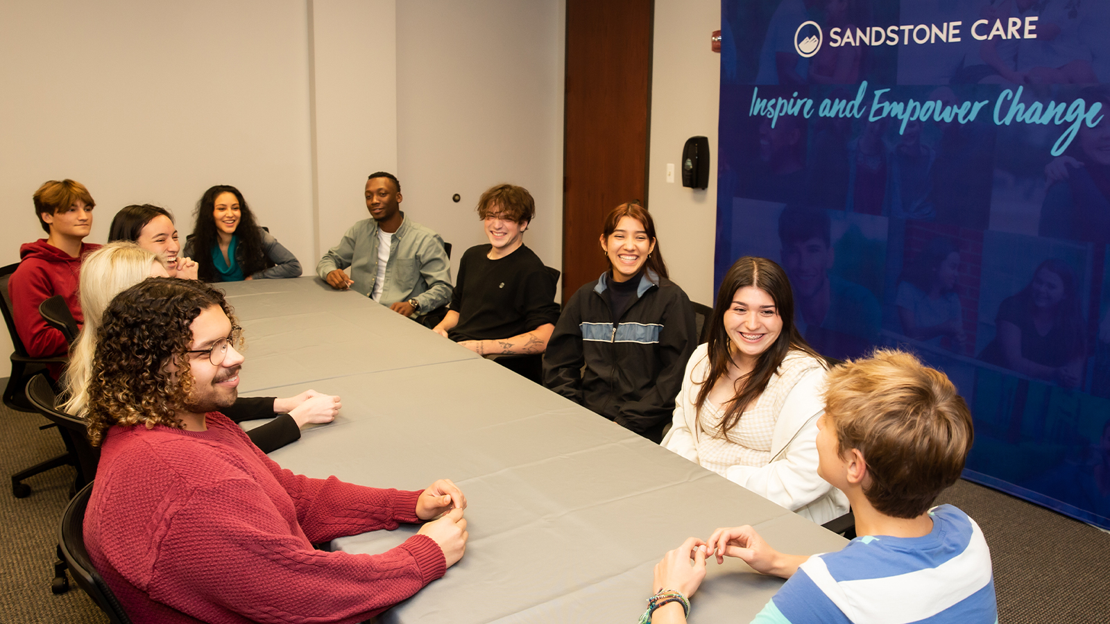 People seated around a table in a group meeting.