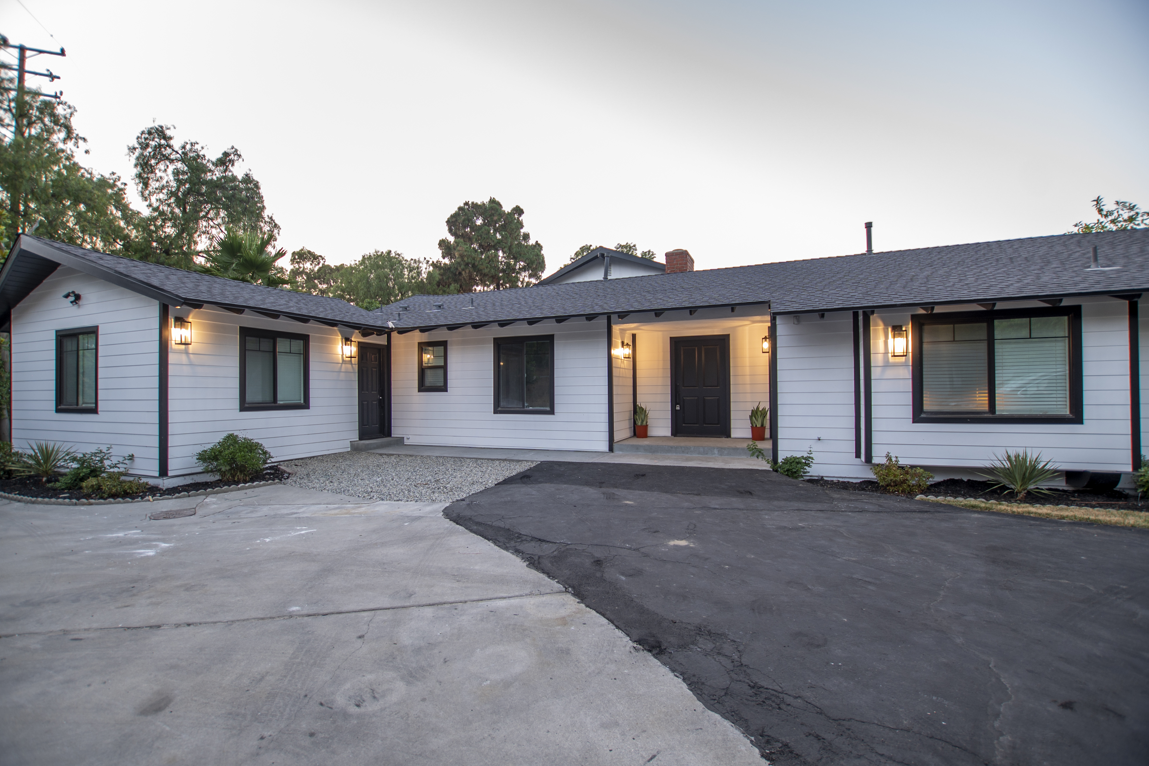 Front entrance with white siding and soft outdoor lighting