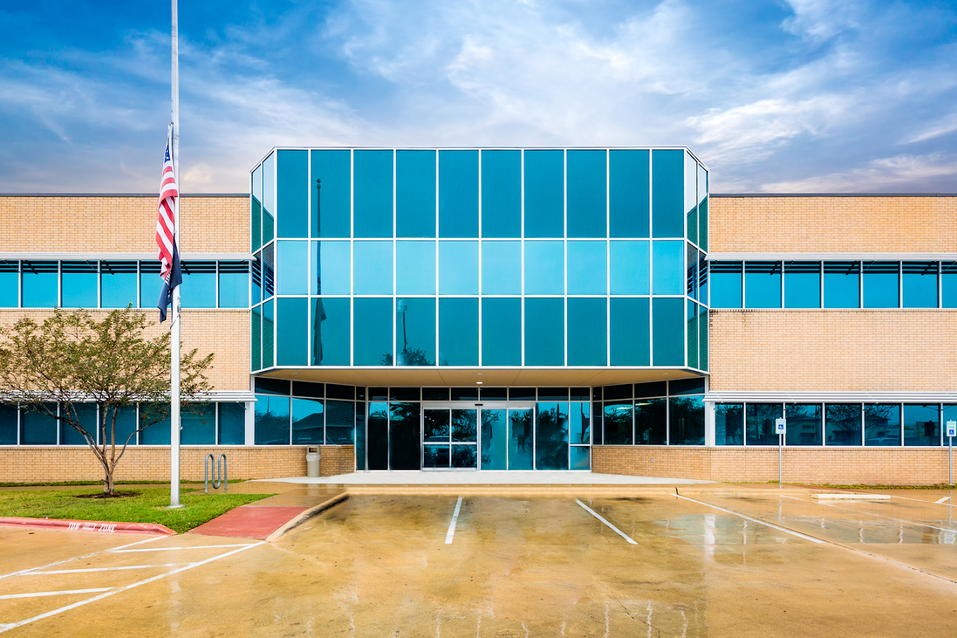 A modern rehab facility exterior with large glass windows and brick walls.
