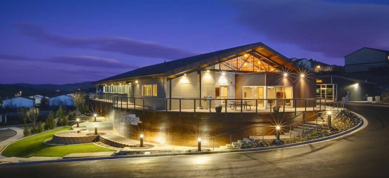 Modern treatment facility exterior with outdoor seating at dusk