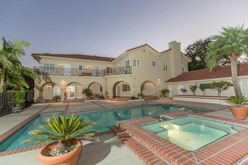 Villa with a pool, spa, and landscaping.