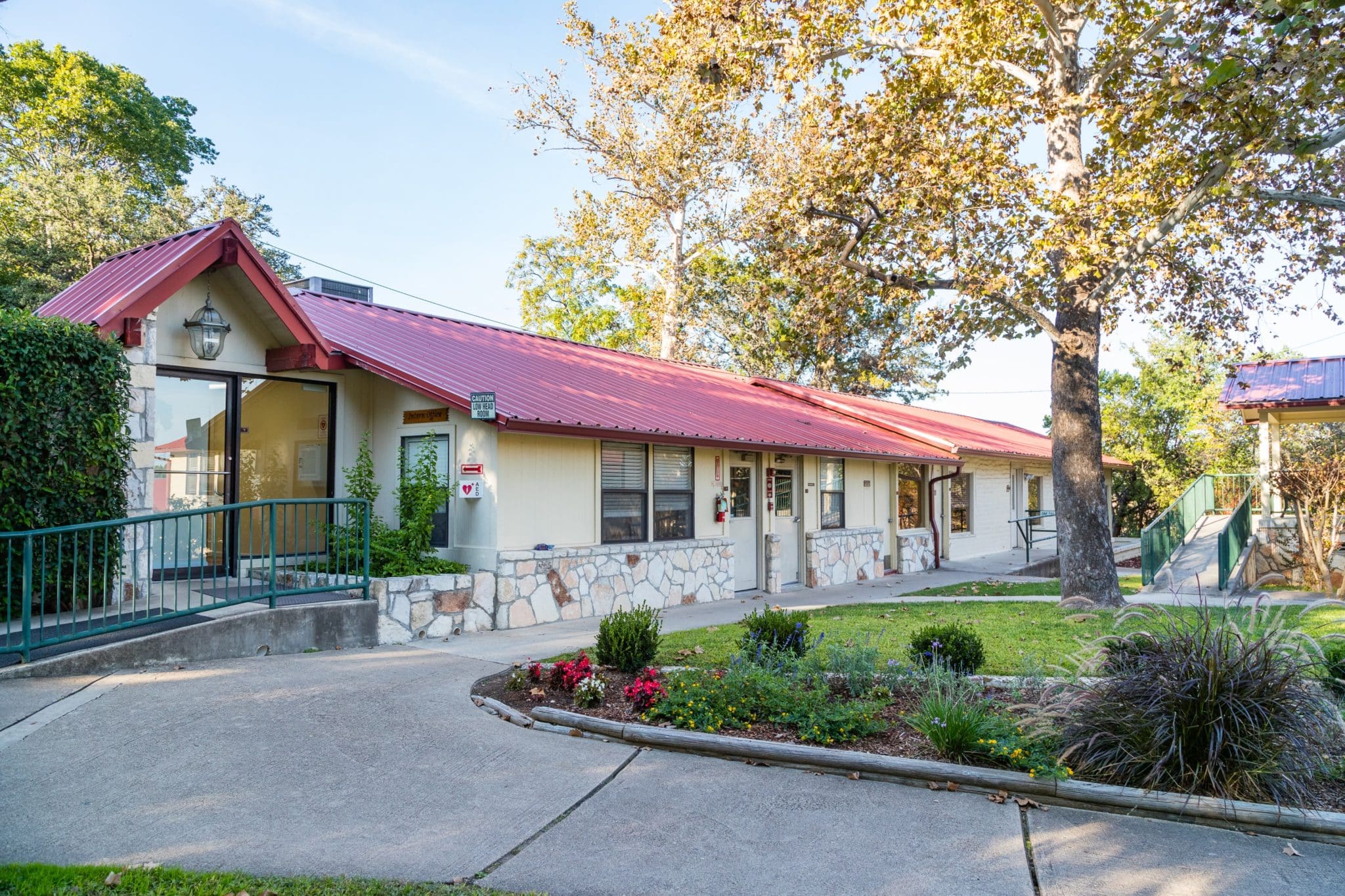 Main building with red roof and stone facade