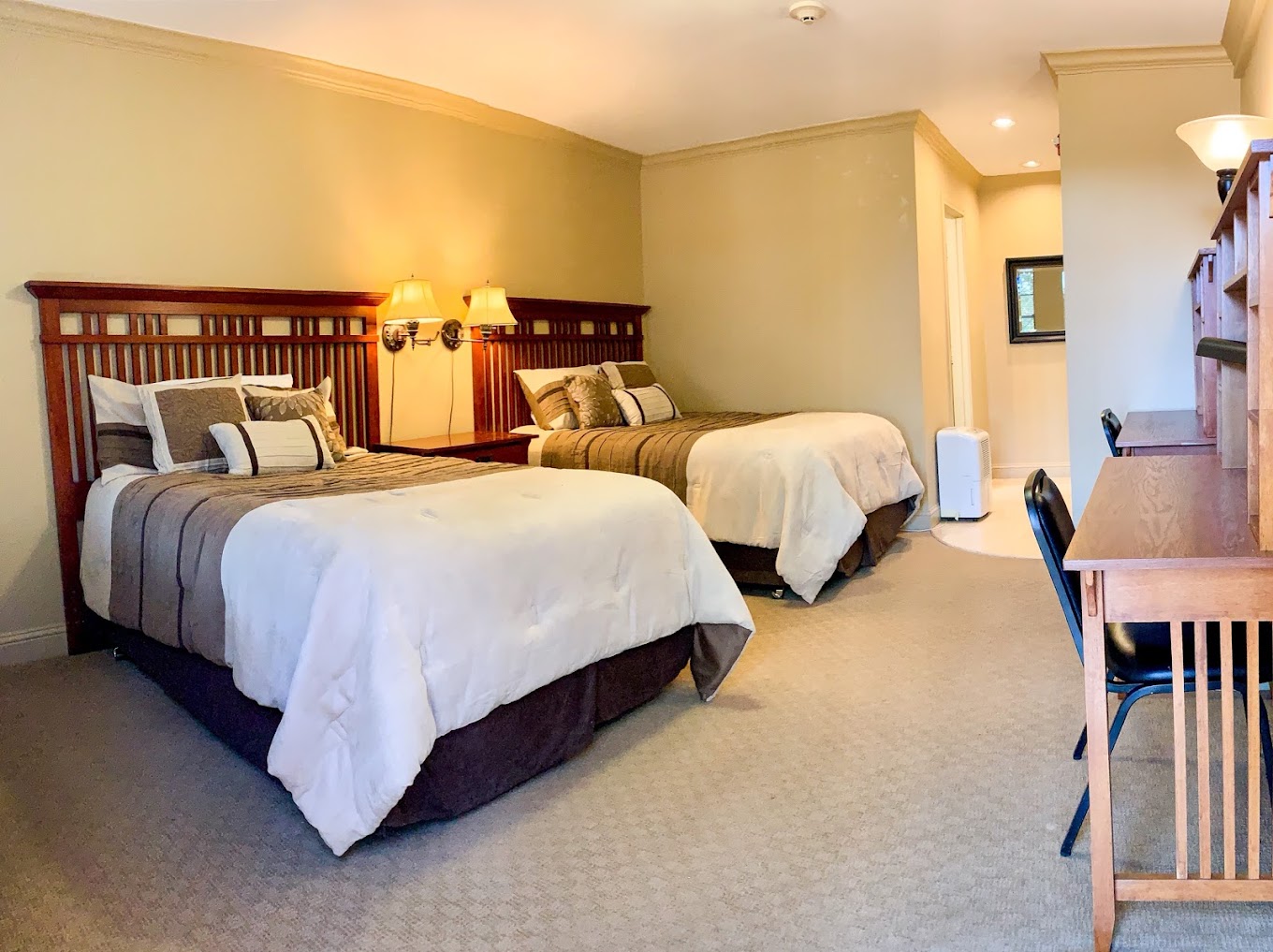 Cozy bedroom with two beds, warm lighting, and study desks