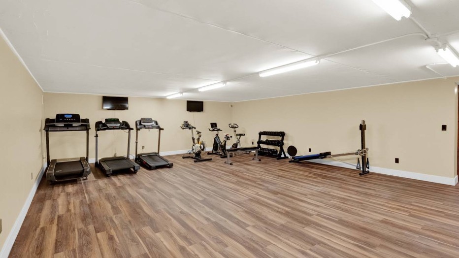 Fitness room with treadmills, exercise bikes, weights, and workout equipment