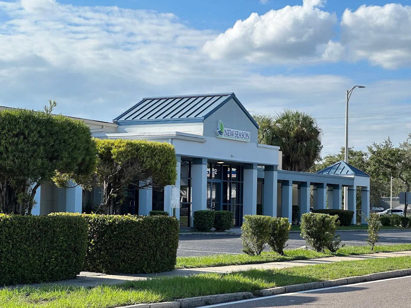 Clinic building with New Season logo and trimmed bushes out front
