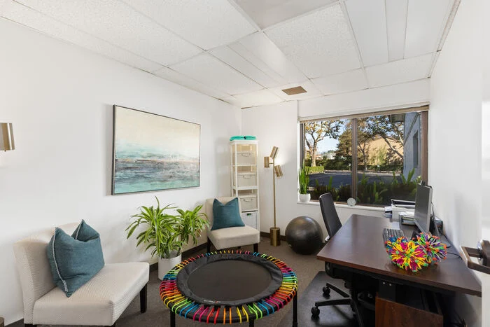 Therapy office with mini trampoline and sensory equipment