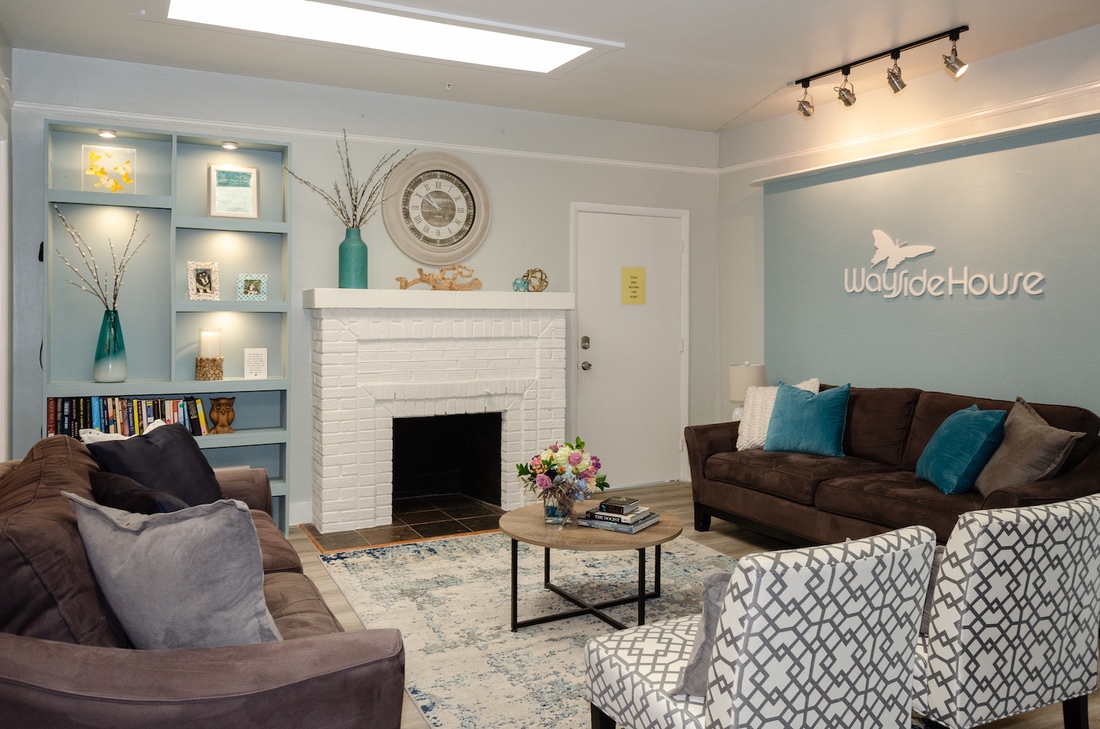 Cozy living room with couches and white brick fireplace