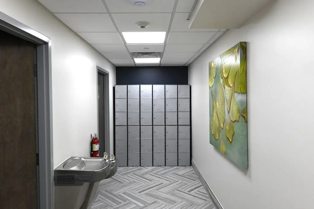 Hallway with lockers, artwork, and a water fountain