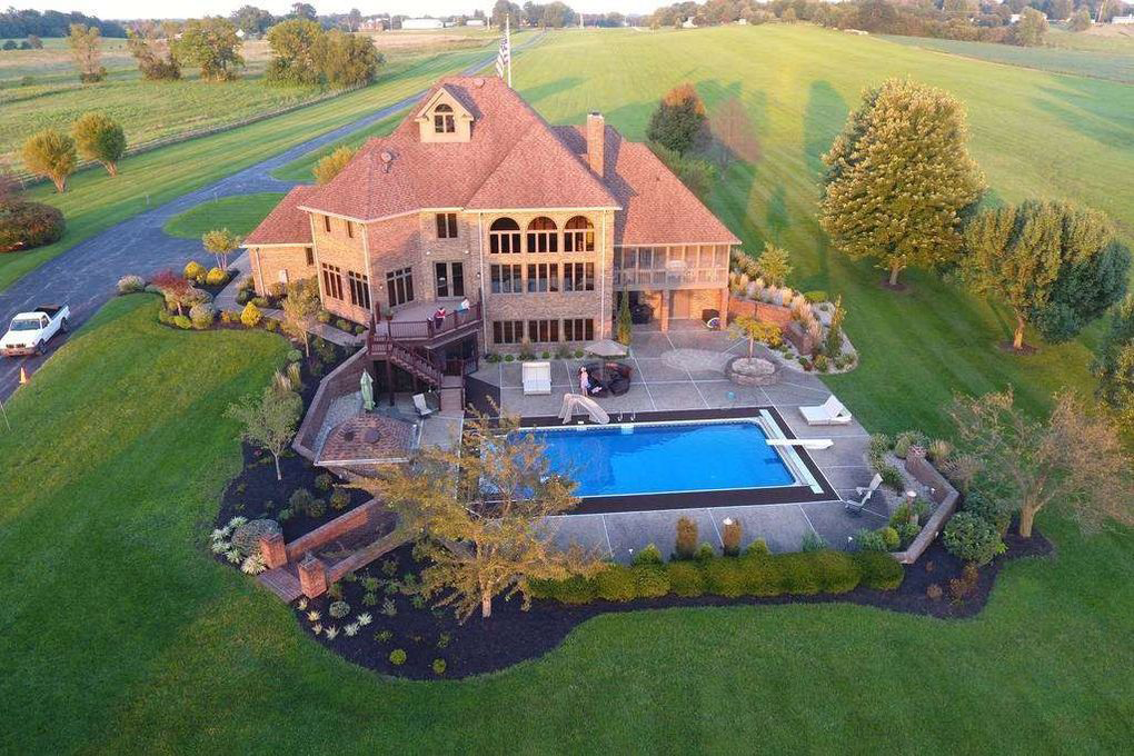 Aerial view of luxury rehab facility with pool and open land