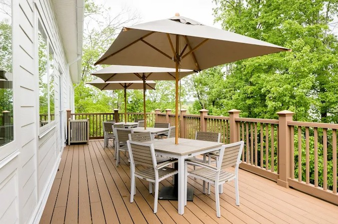 Outdoor deck with tables, chairs, and large patio umbrellas