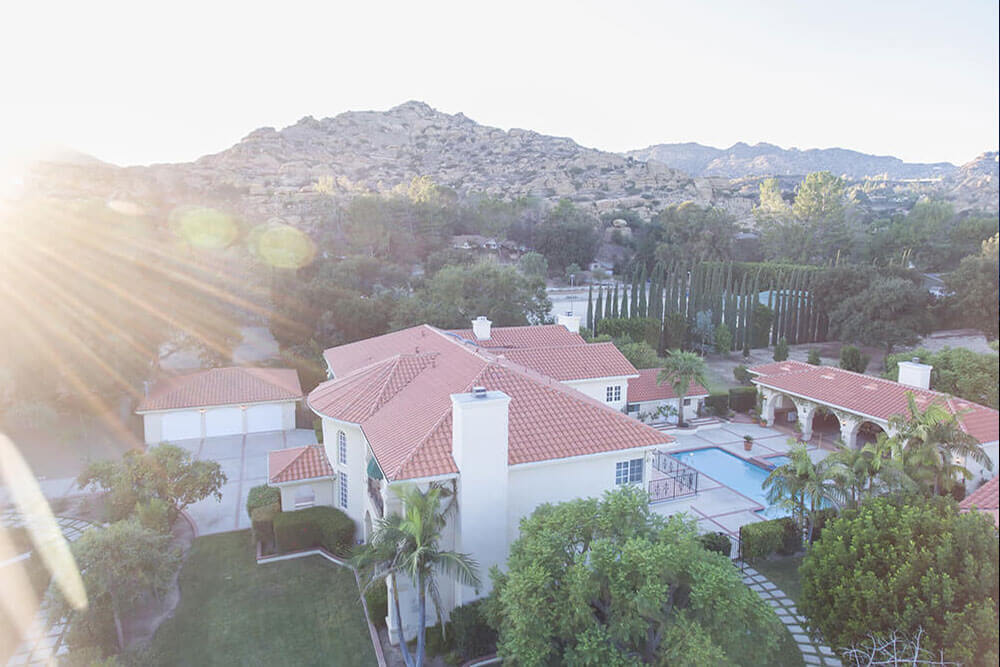 Aerial view of a facility with a pool, and greenery.