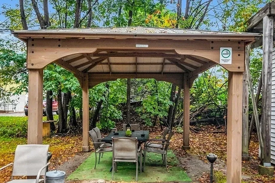 Covered outdoor patio with table seating surrounded by trees