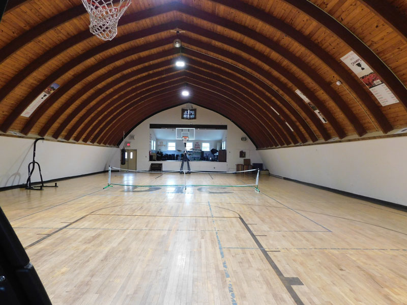 Indoor gym with basketball hoop and open floor space