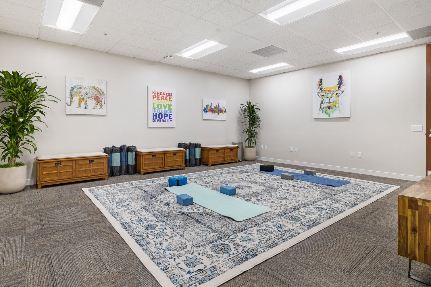 Yoga room with mats, blocks, and wall art