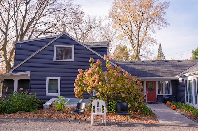 Gray residential home with front entrance and chairs