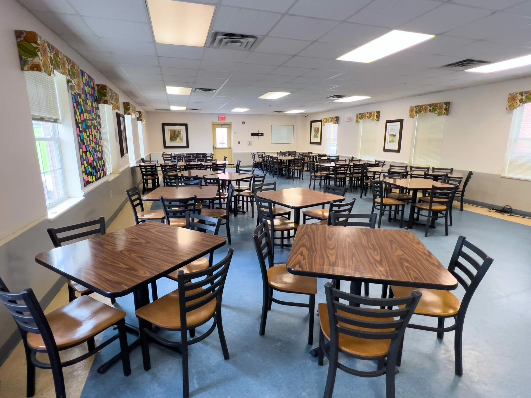 Spacious dining area with square tables and chairs