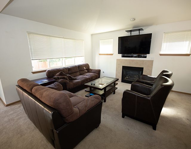 Lounge with sectional couch, armchairs, and wall-mounted TV