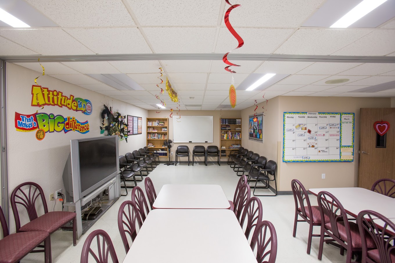 A lively and welcoming common area with ample seating, colorful decor, and various activities, fostering a positive and engaging environment.