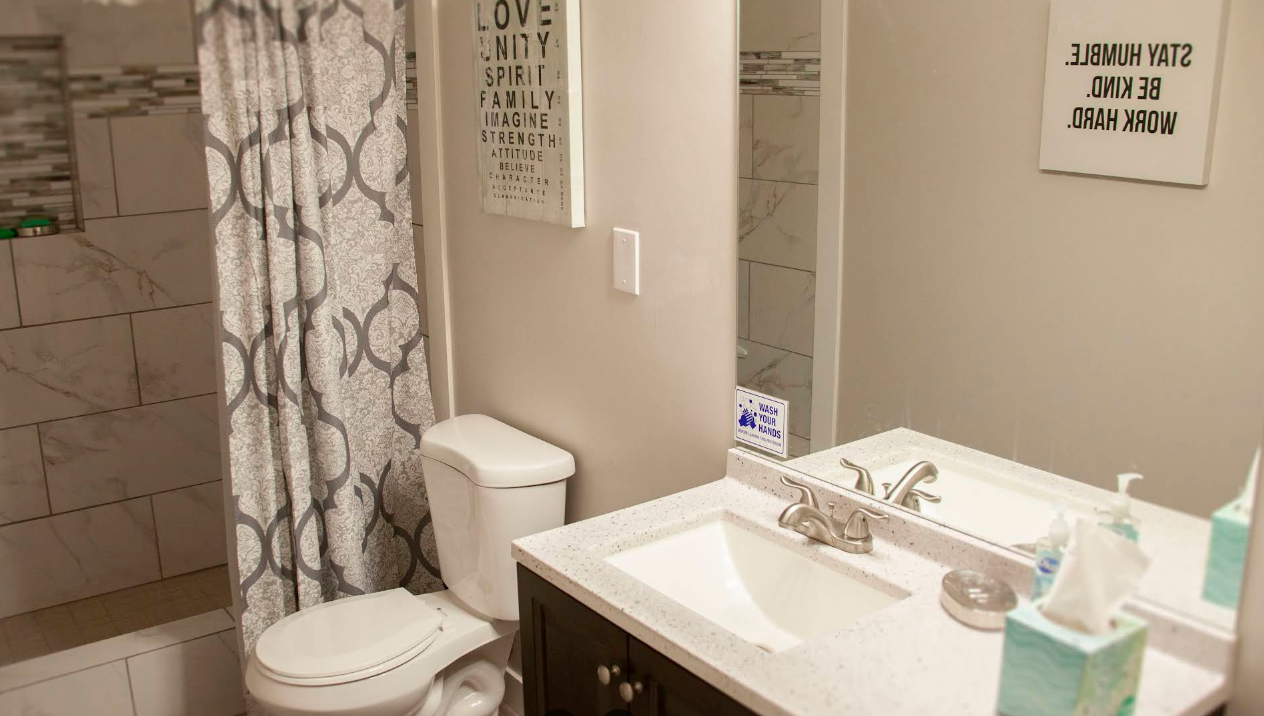 Clean shared bathroom with shower, sink, and toilet