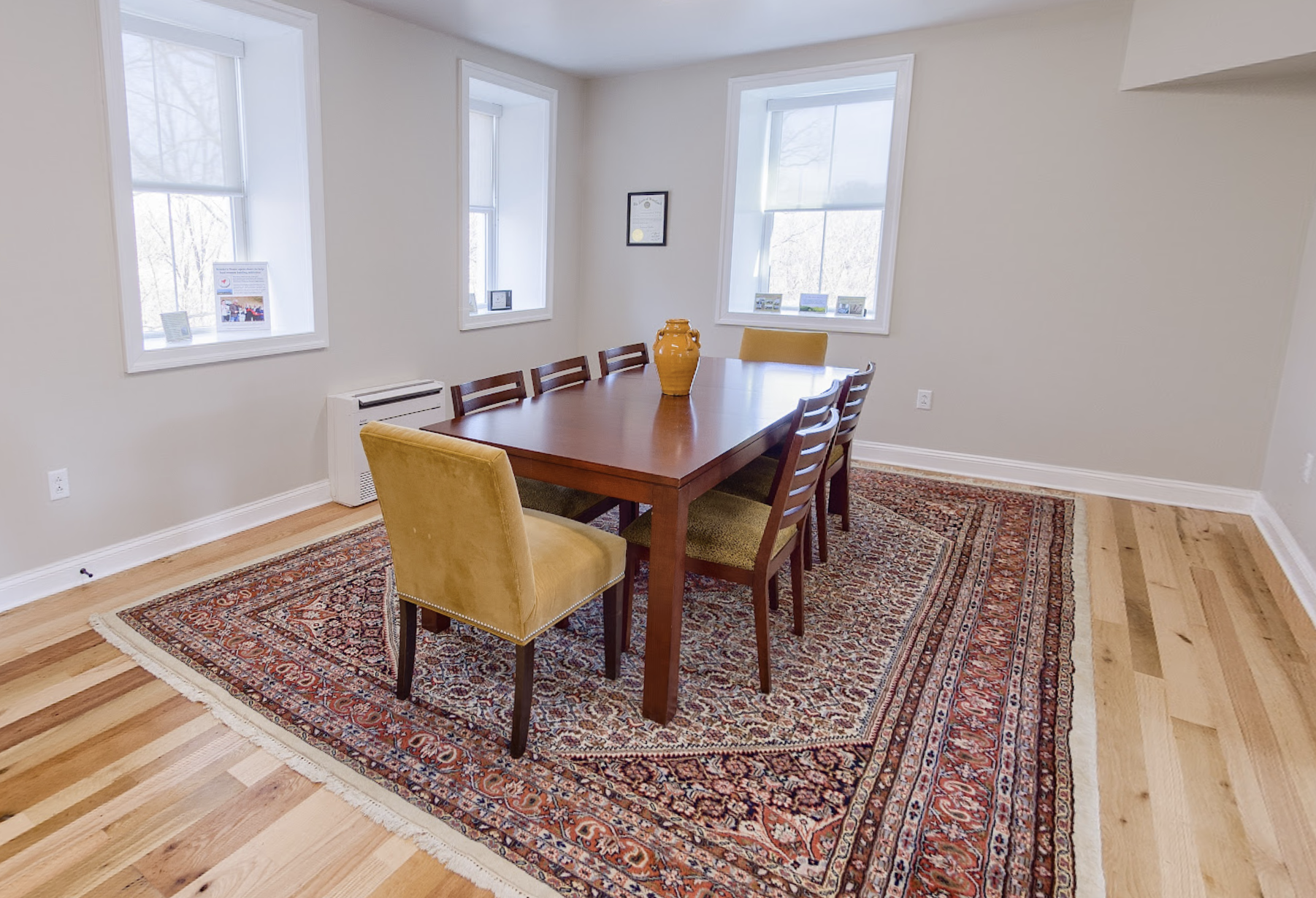 Dining room with wooden table, chairs, and patterned rug