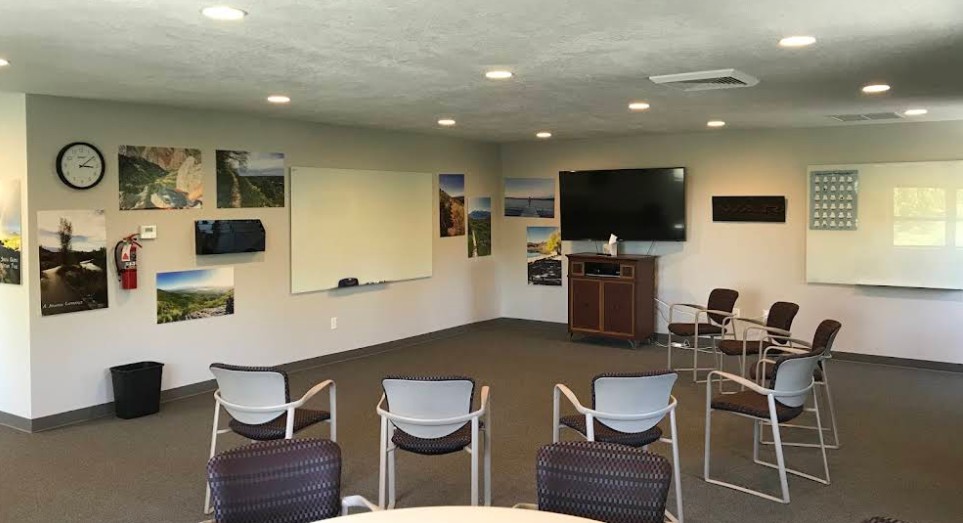Group therapy room with chairs, TV, and whiteboards