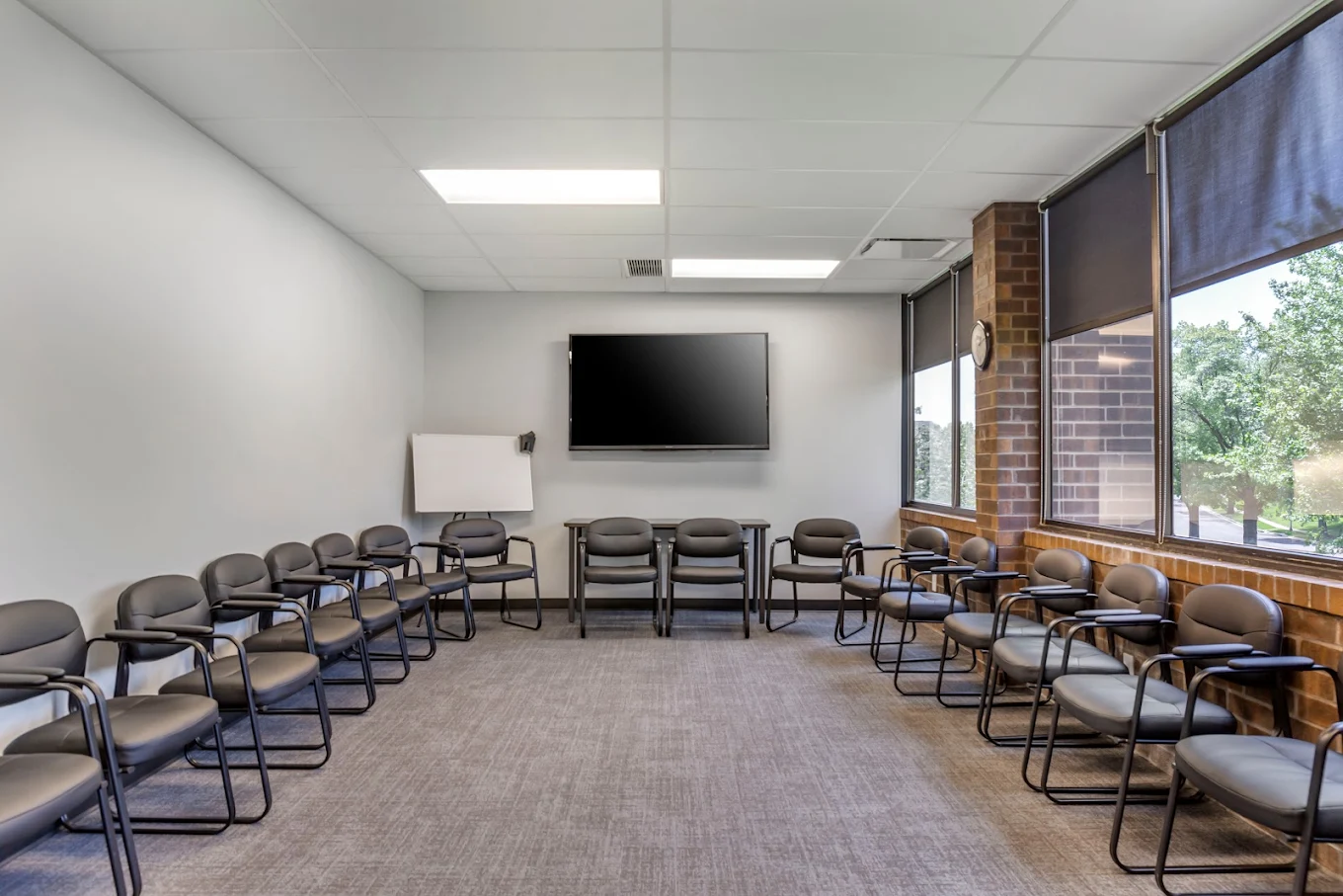 Chairs arranged in circle facing TV in group therapy room